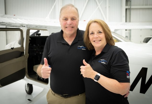 Owners smiling in front of plane