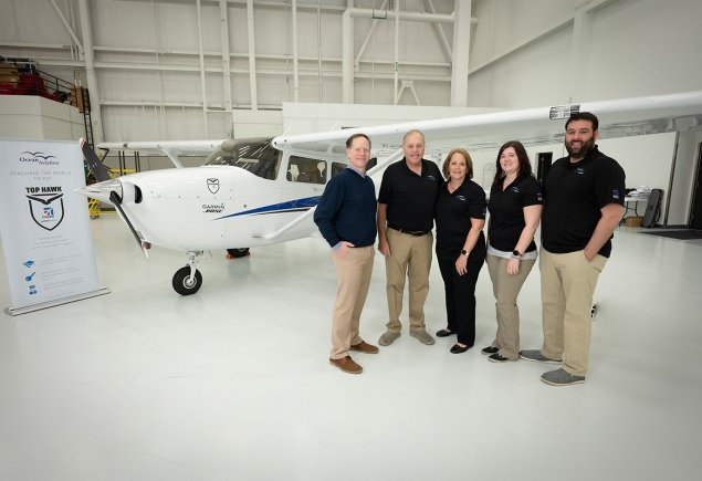 staff stands in front of plane