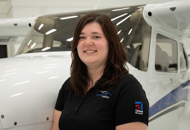 woman stands against plane