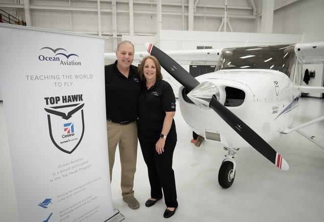 Owners stand in front of plane