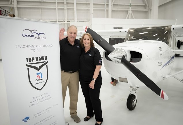 Staff in front of plane and information banner