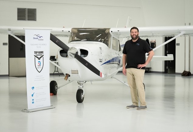 OA Employee stands in front of a plane